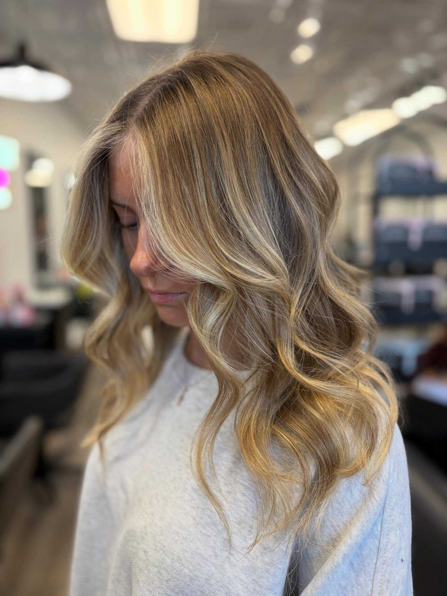 Blonde woman with wavy hair in a salon setting.