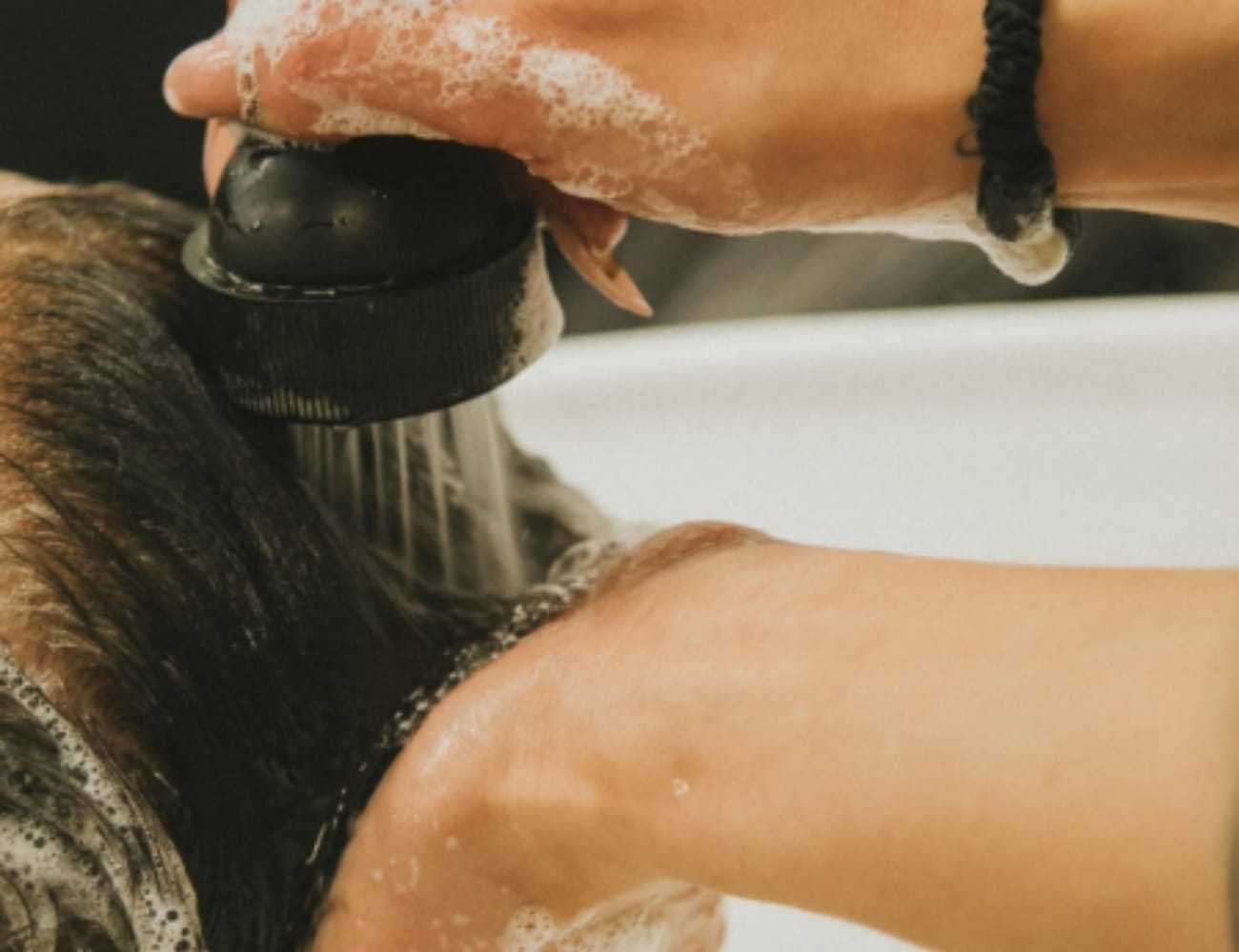 Person getting hair washed with shampoo at a salon.